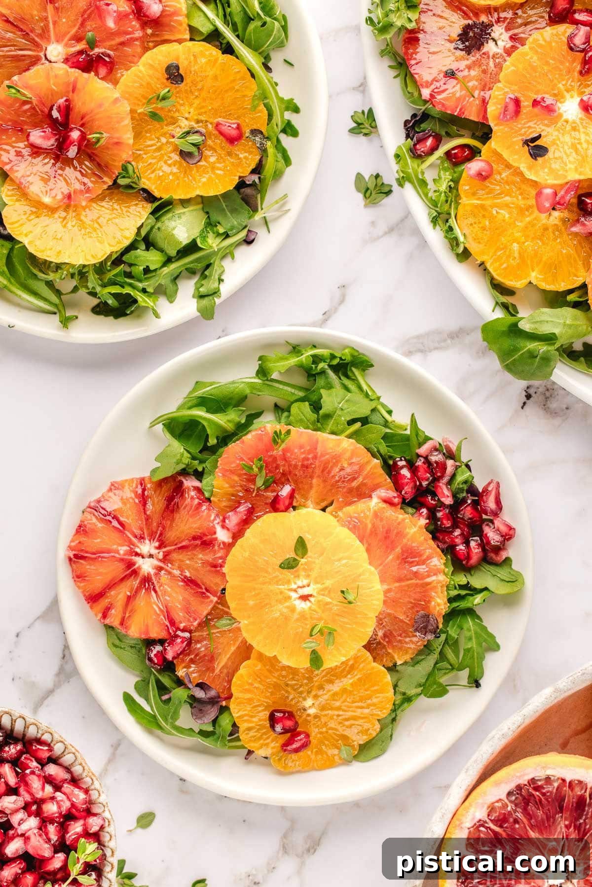 Two small white round plates topped with citrus salad recipe. 