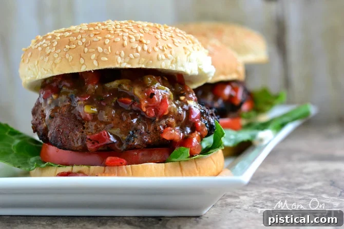 Close-up of a skillet filled with raw burger patties mixed with ingredients, ready for grilling