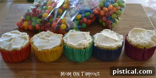 Cupcakes with a light layer of white frosting, ready for colorful decorations