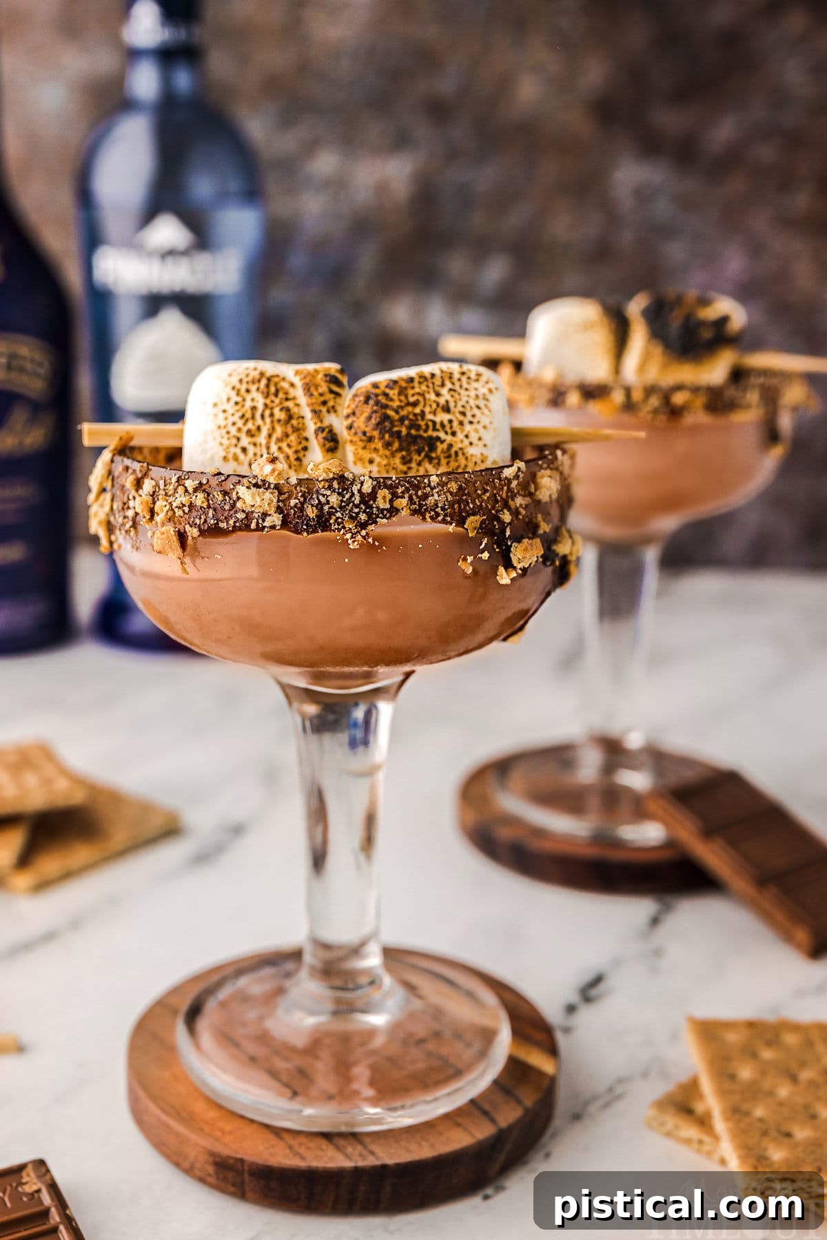 Sweet Campfire Martini 6 Two Smores martini with toasted marshmallow garnish and chocolate and graham cracker rim sitting on coasters ready to be enjoyed.