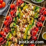 Top down view of antipasto skewers on a sheet pan drizzled with balsamic glaze and ready to eat.