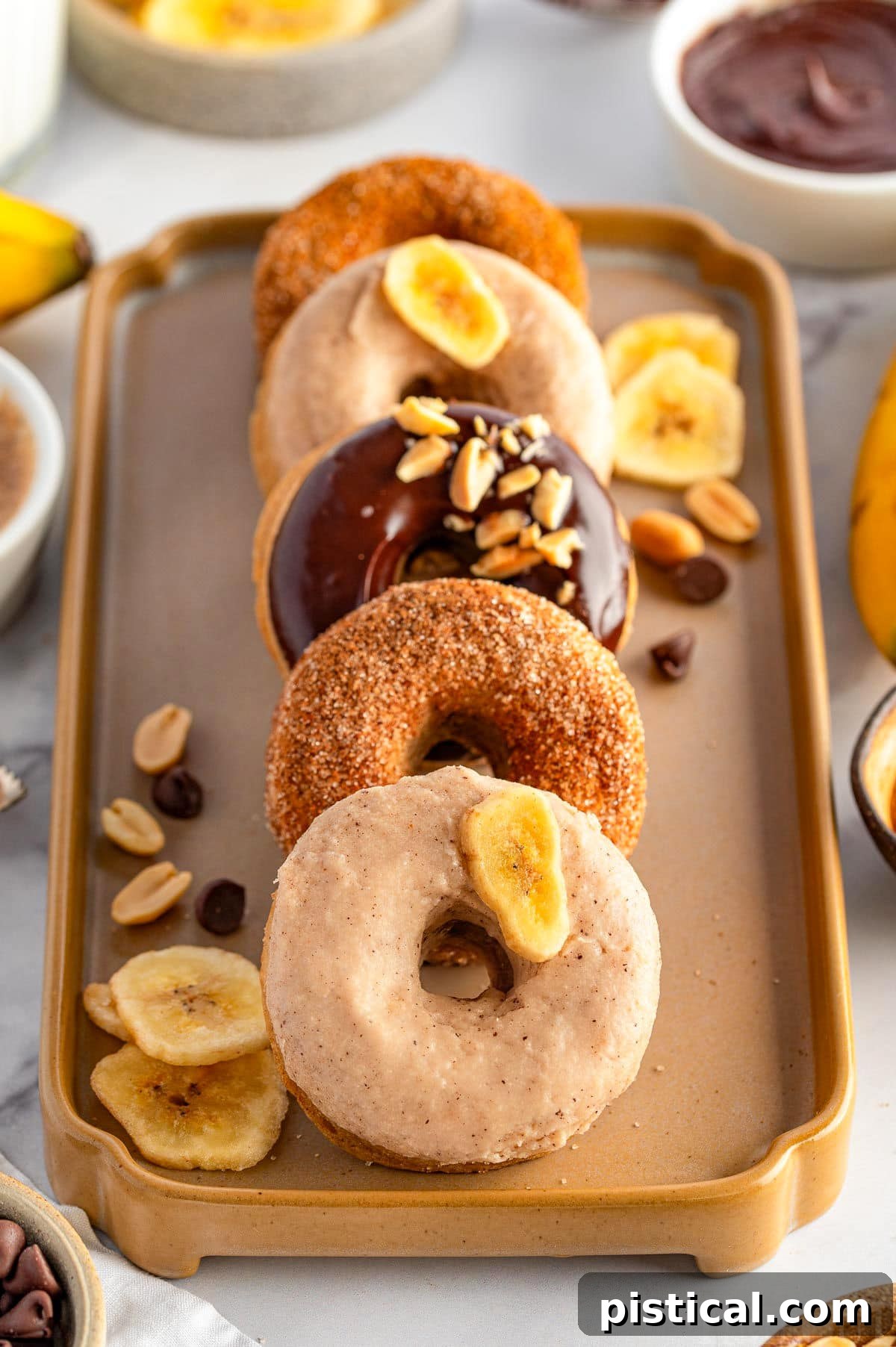 Delightful Banana Doughnuts 9 A vibrant display of banana donuts presented on a decorative tray, adorned with various toppings and garnishes, highlighting their delicious appeal.