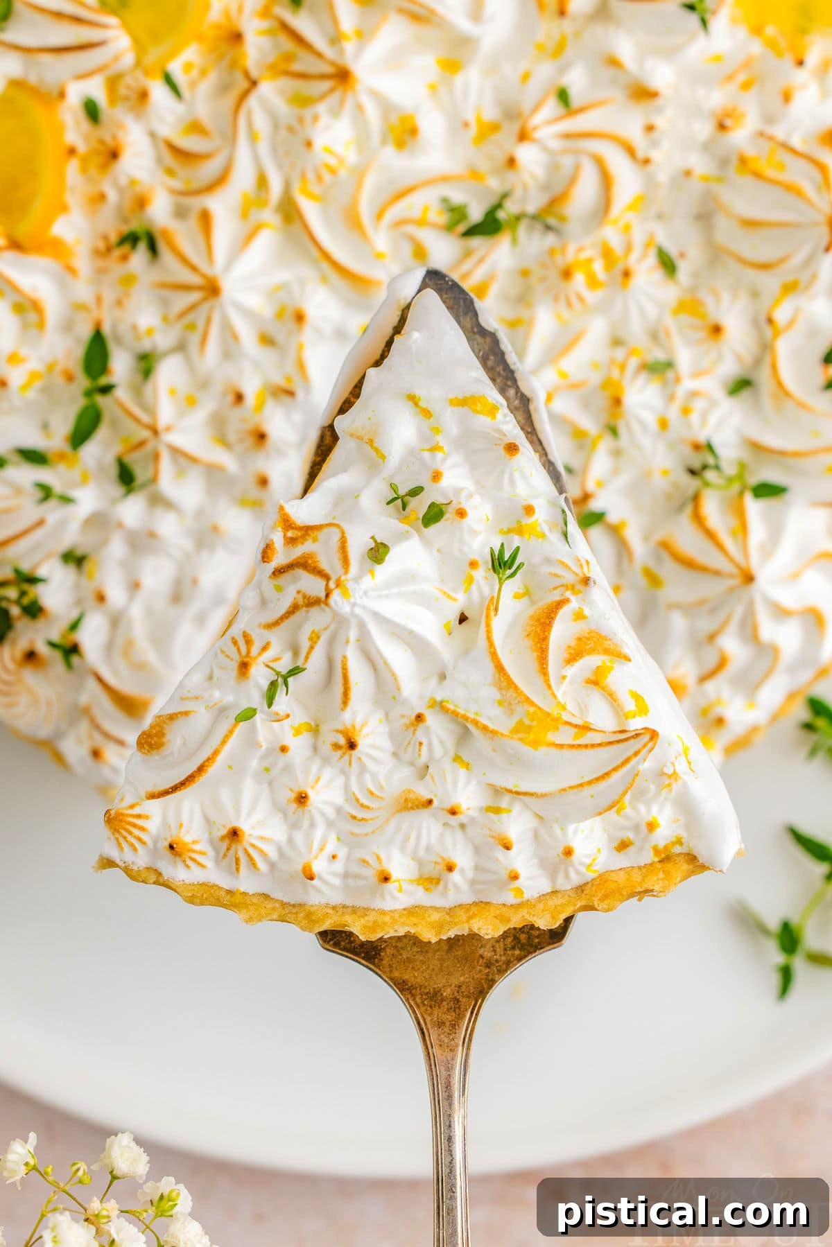 Zesty Lemon Cloud Tart 6 A delicious slice of Lemon Meringue Tart, perfectly plated, with a cake server holding another slice ready to be served, highlighting the layers of crust, lemon, and meringue.