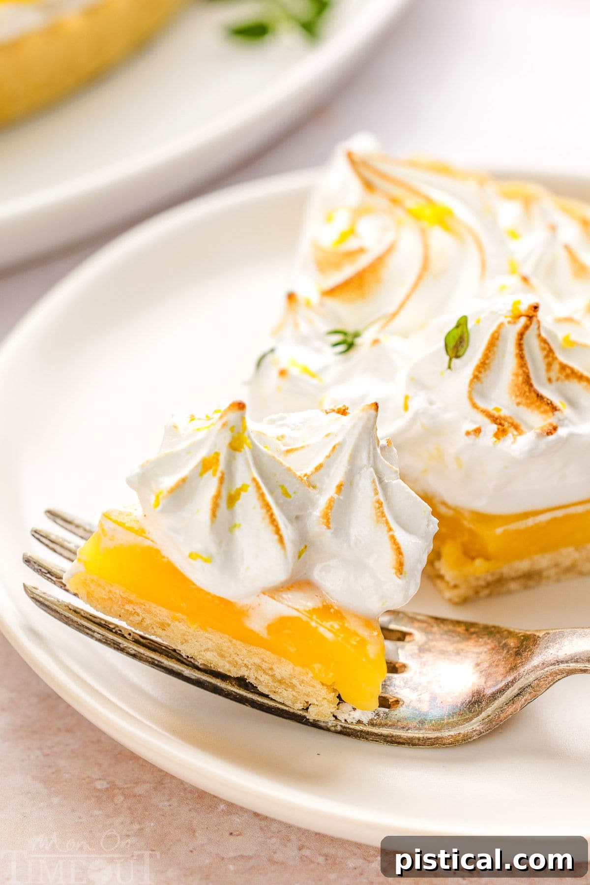Zesty Lemon Cloud Tart 8 A close-up shot of a slice of Lemon Meringue Tart on a white plate, with a fork gently lifting a perfect bite, highlighting the layers and inviting texture.