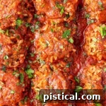 Porcupine Meatballs with fresh parsley sprinkled on top. The meatballs are lined up in a baking pan.