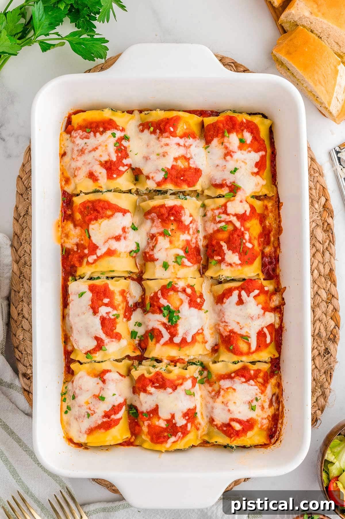 Top down shot of lasagna roll ups in a white casserole dish baked and ready to be served.