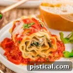 Lasagna Roll Ups plated with salad and bread on a dinner plate.