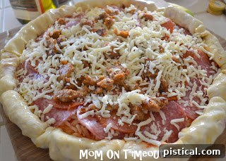 The pizza with its fully crimped and stuffed crust, ready for baking.