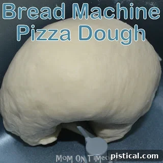 Bread machine kneading pizza dough. Shows the dough forming into a ball inside the bread machine.