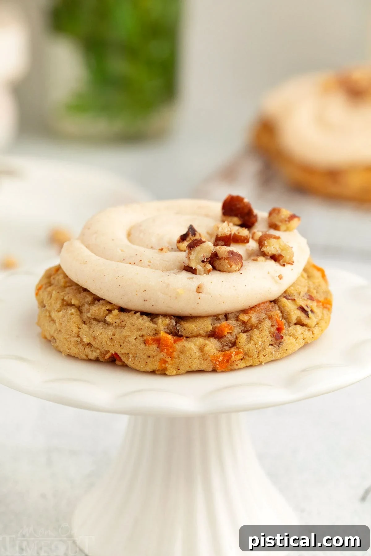 Cream Cheese Frosted Carrot Cookies 7 A single, perfectly frosted Carrot Cake Cookie resting elegantly on a white cookie stand, highlighting its appeal.