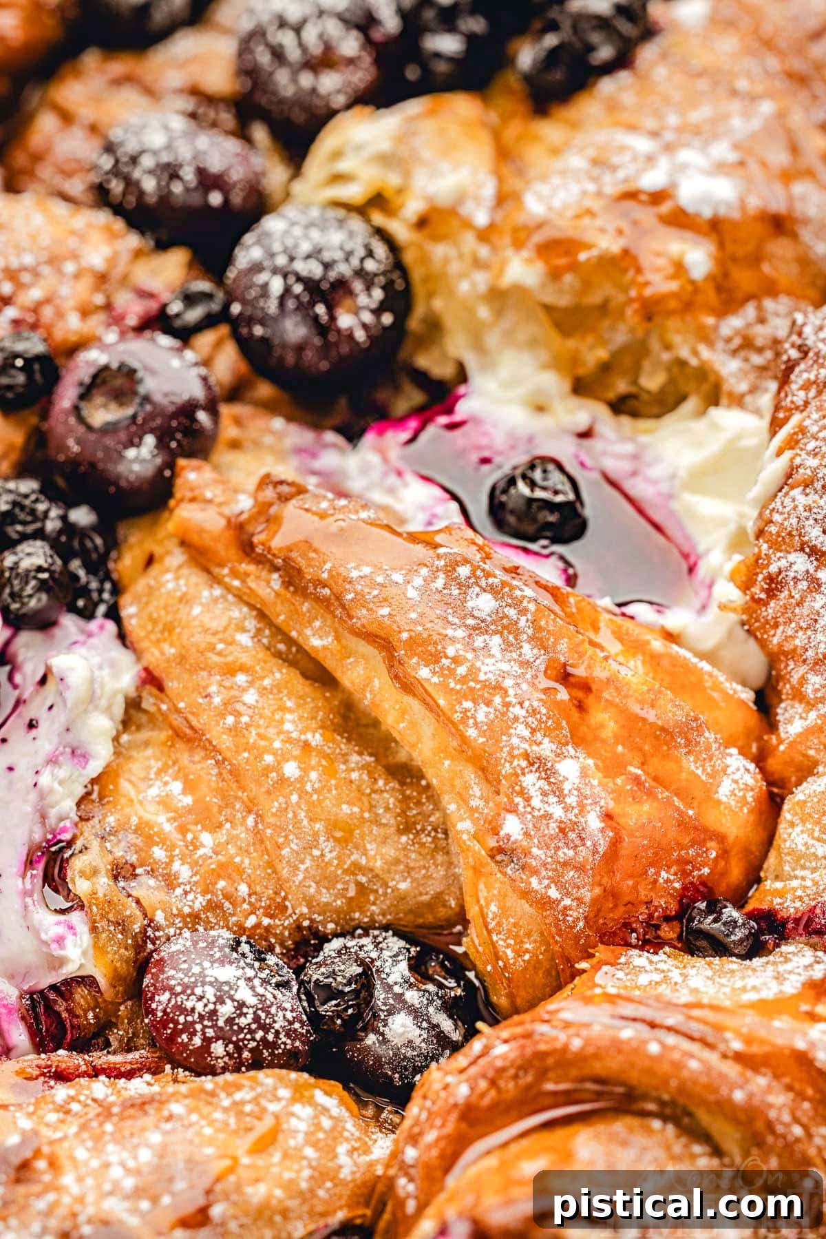 Luscious Blueberry Croissant French Toast Bake 4 Close up look at maple syrup glistening on croissant french toast bake with blueberries.