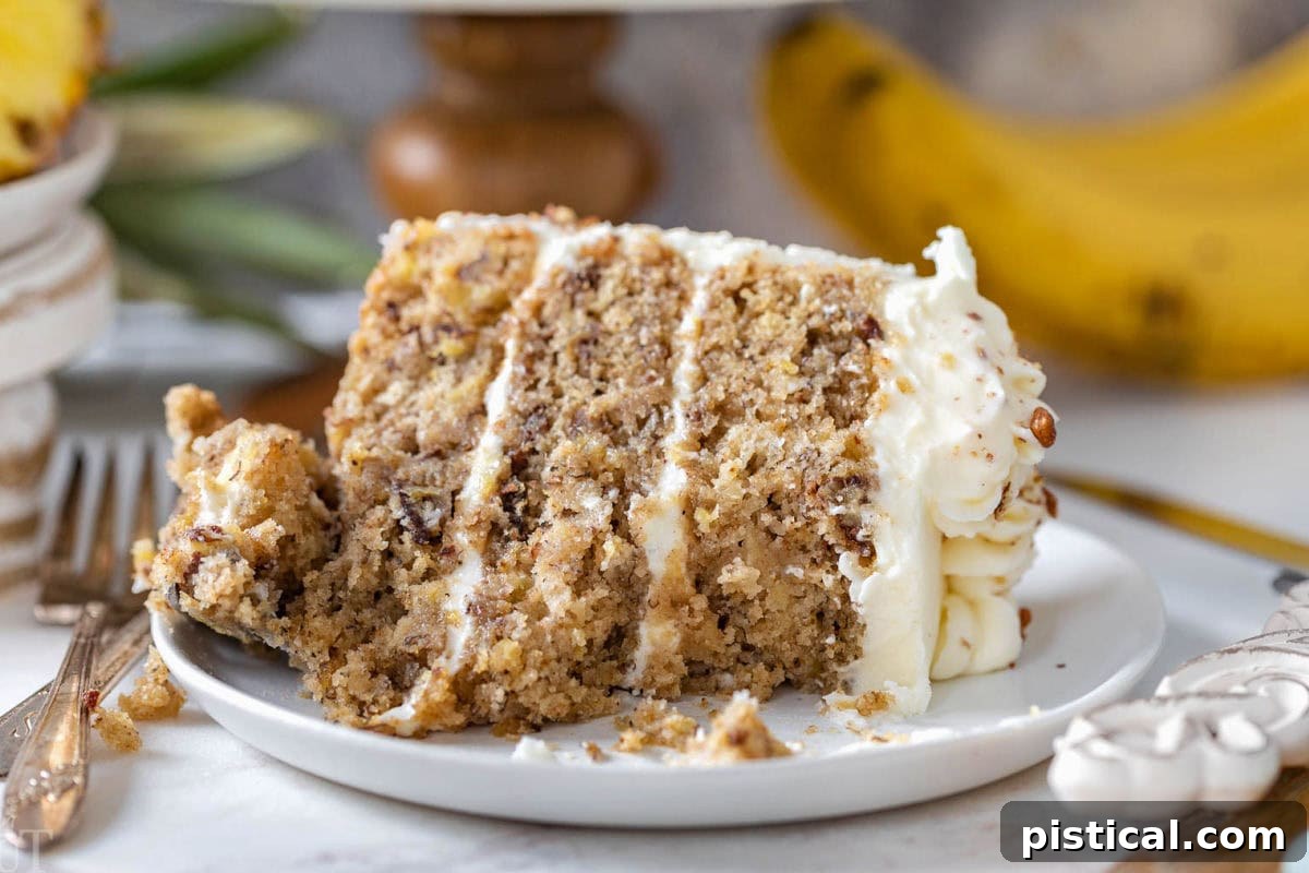 A close-up of a slice of old-fashioned Hummingbird Cake, showing a few bites taken from it, resting on a white plate – inviting you to try a bite yourself.