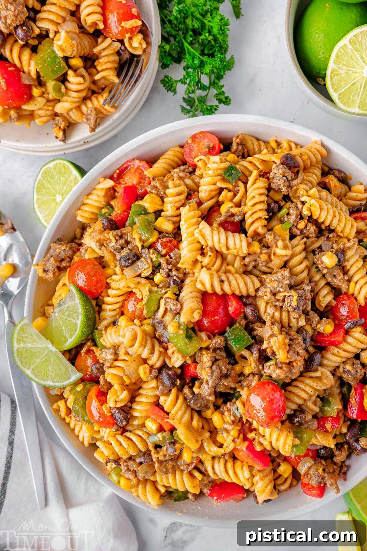 Ranch Hand Pasta Salad 3 An overhead shot showcasing two-thirds of a large bowl of Cowboy Pasta Salad. The vibrant mix includes ground beef, dark black beans, bright fresh vegetables, and a glossy taco-lime dressing, highlighting its appealing textures.