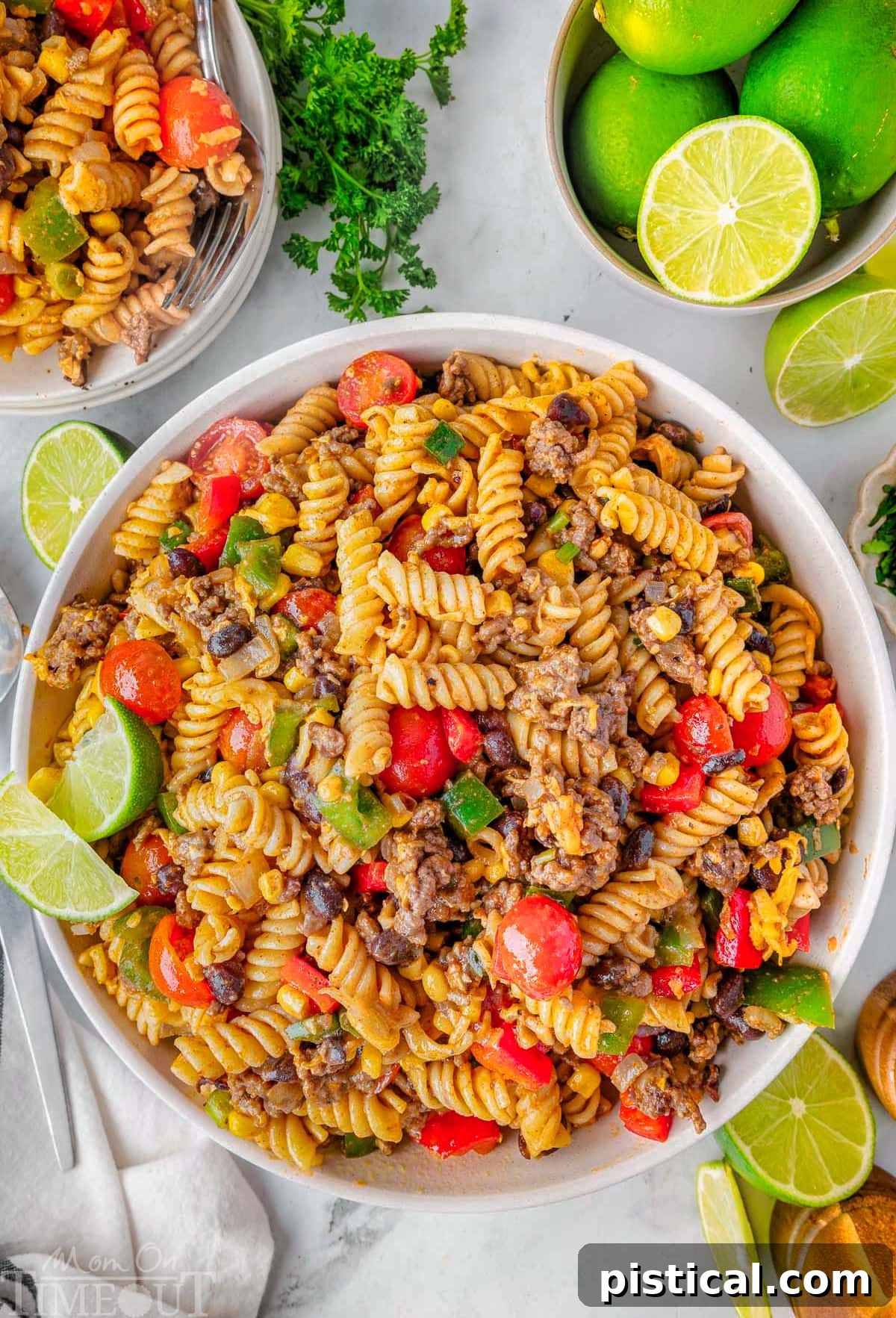 Ranch Hand Pasta Salad 7 An inviting overhead shot of the Cowboy Pasta Salad recipe served in a large, elegant white bowl, beautifully garnished with fresh lime wedges for a touch of citrusy appeal.