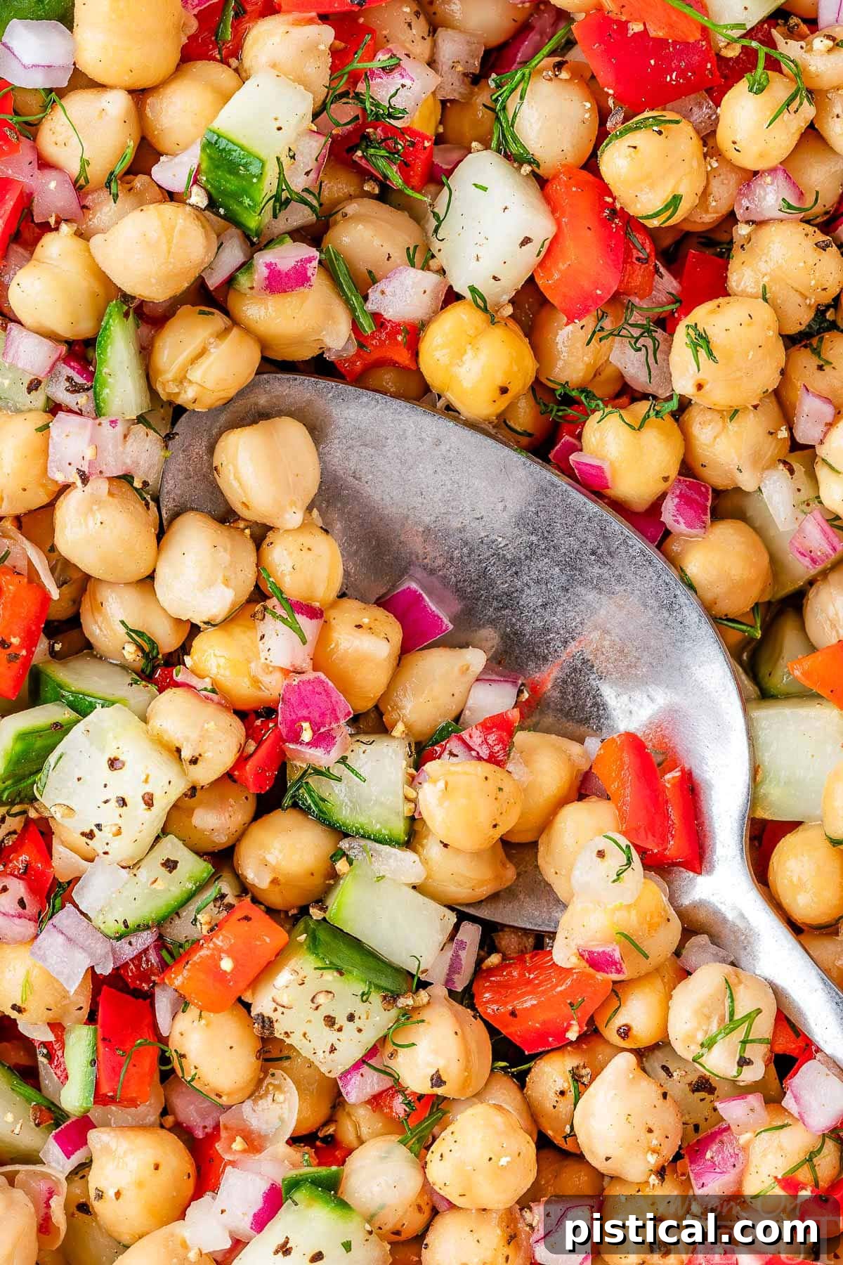 Overhead look at a closeup of a garbanzo salad in a large white bowl.