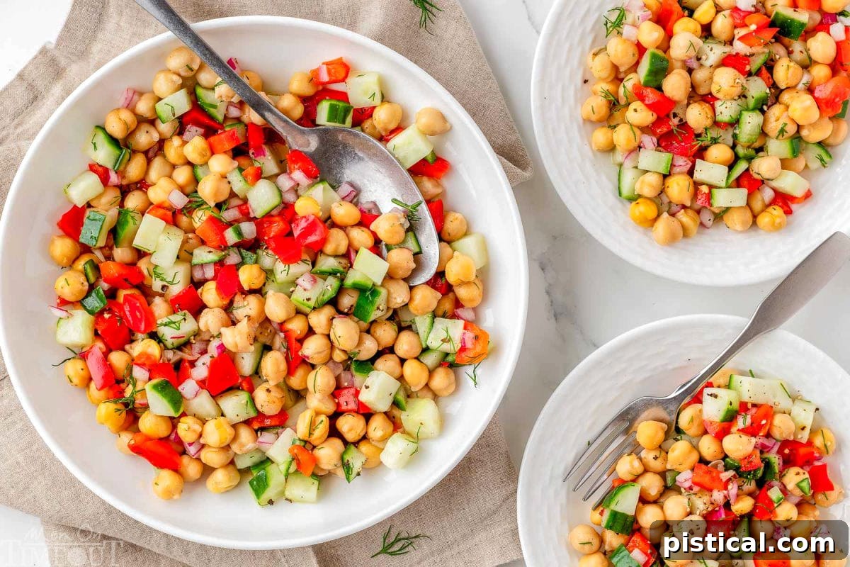 Wide shot of three plates with chickpeas salad recipe served on them. 