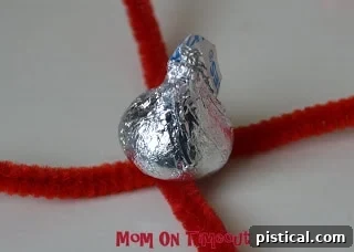 Pipe cleaners pulled up around the Hershey's Kiss and twisted tightly at the top.