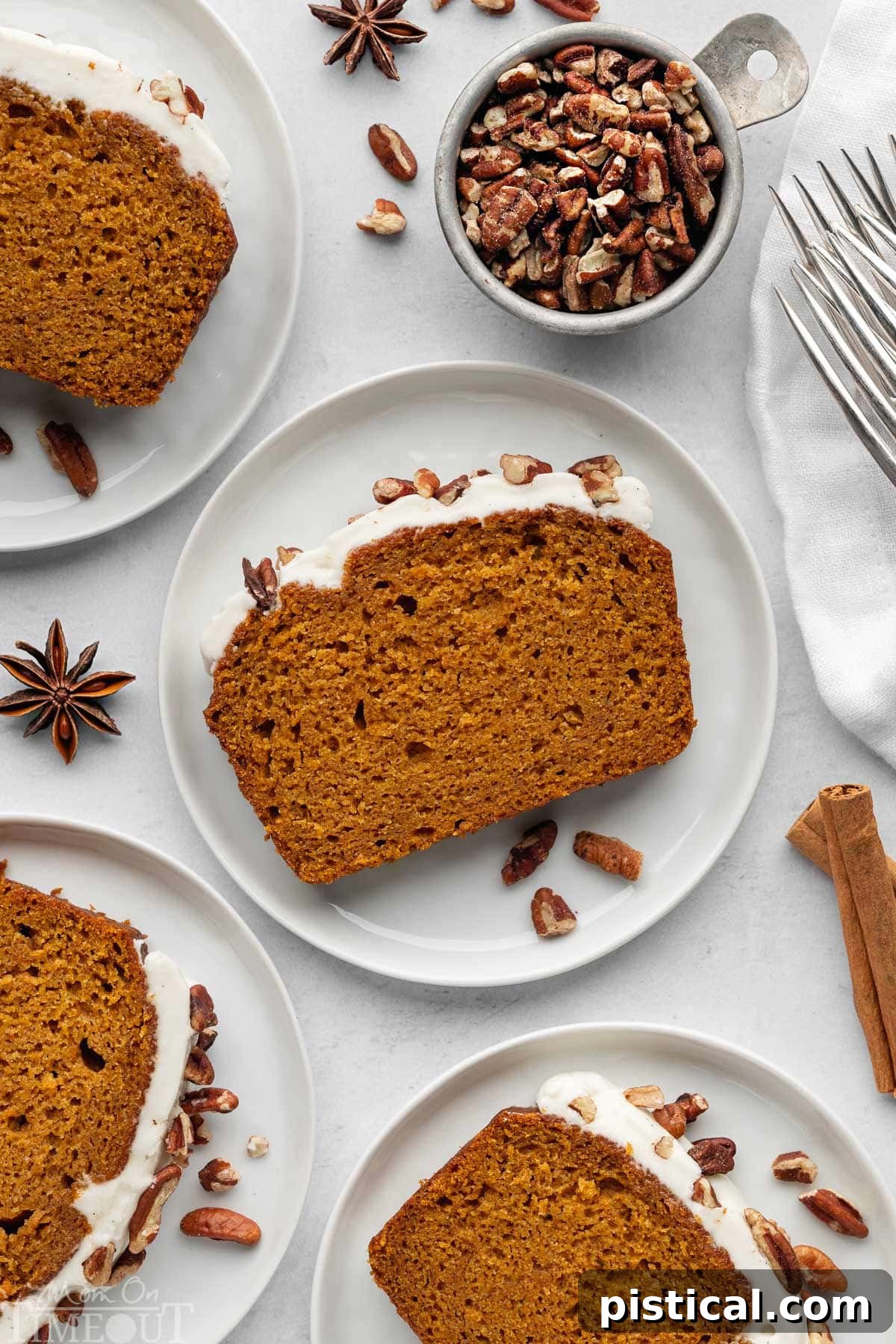 Overhead shot of recipe for pumpkin bread cut into slices and plated. Four plates shown.