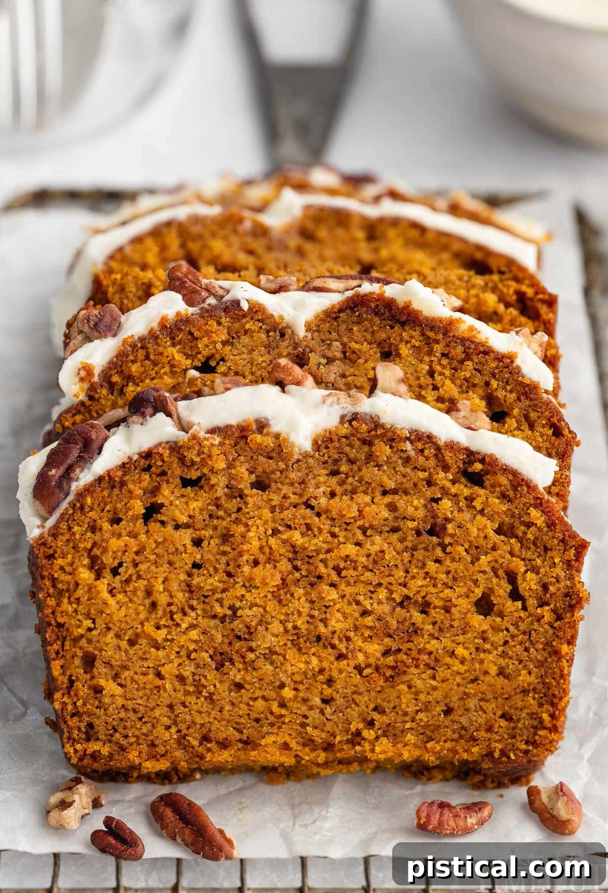 Three slices cut from pumpkin loaf recipe sitting on board. 