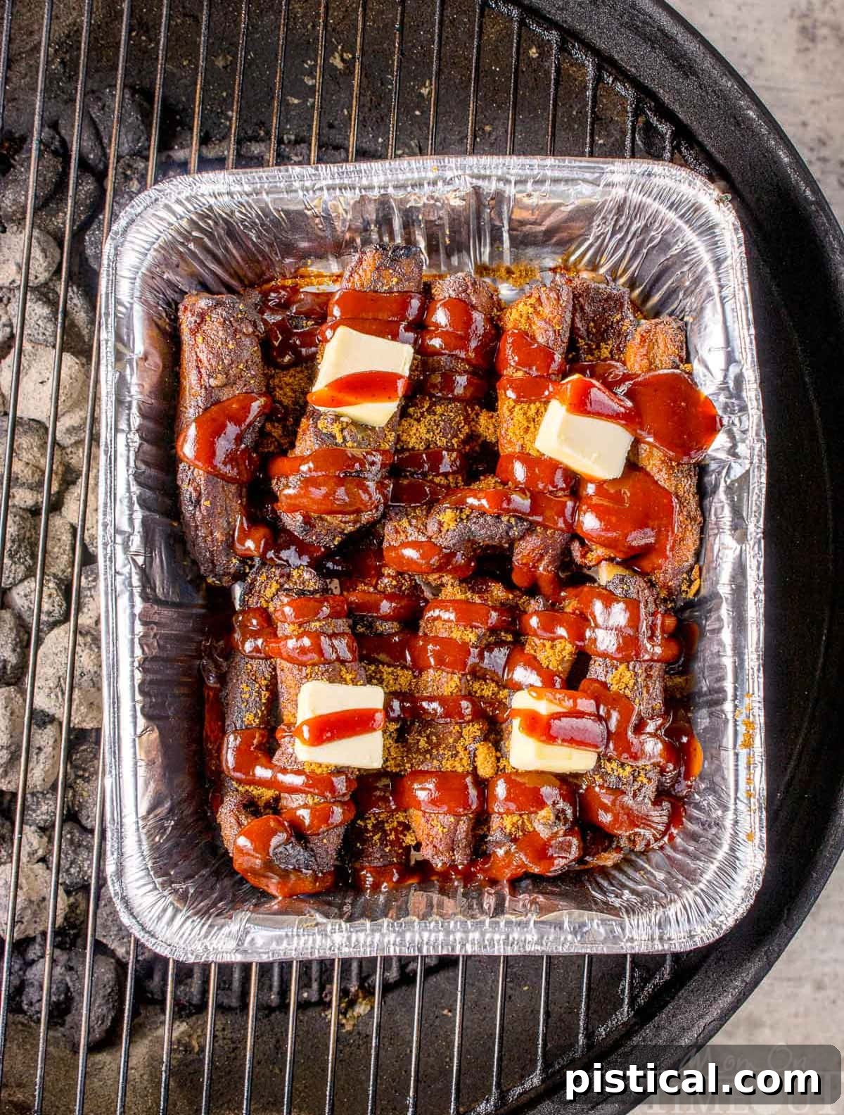 Overhead shot of party ribs recipe on the grill. Ribs are mixed with butter, seasonings and barbecue sauce.