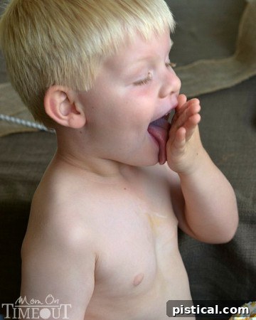 Close-up of Bryce licking caramel and whipped cream from his hand after a messy shake moment. | MomOnTimeout.com