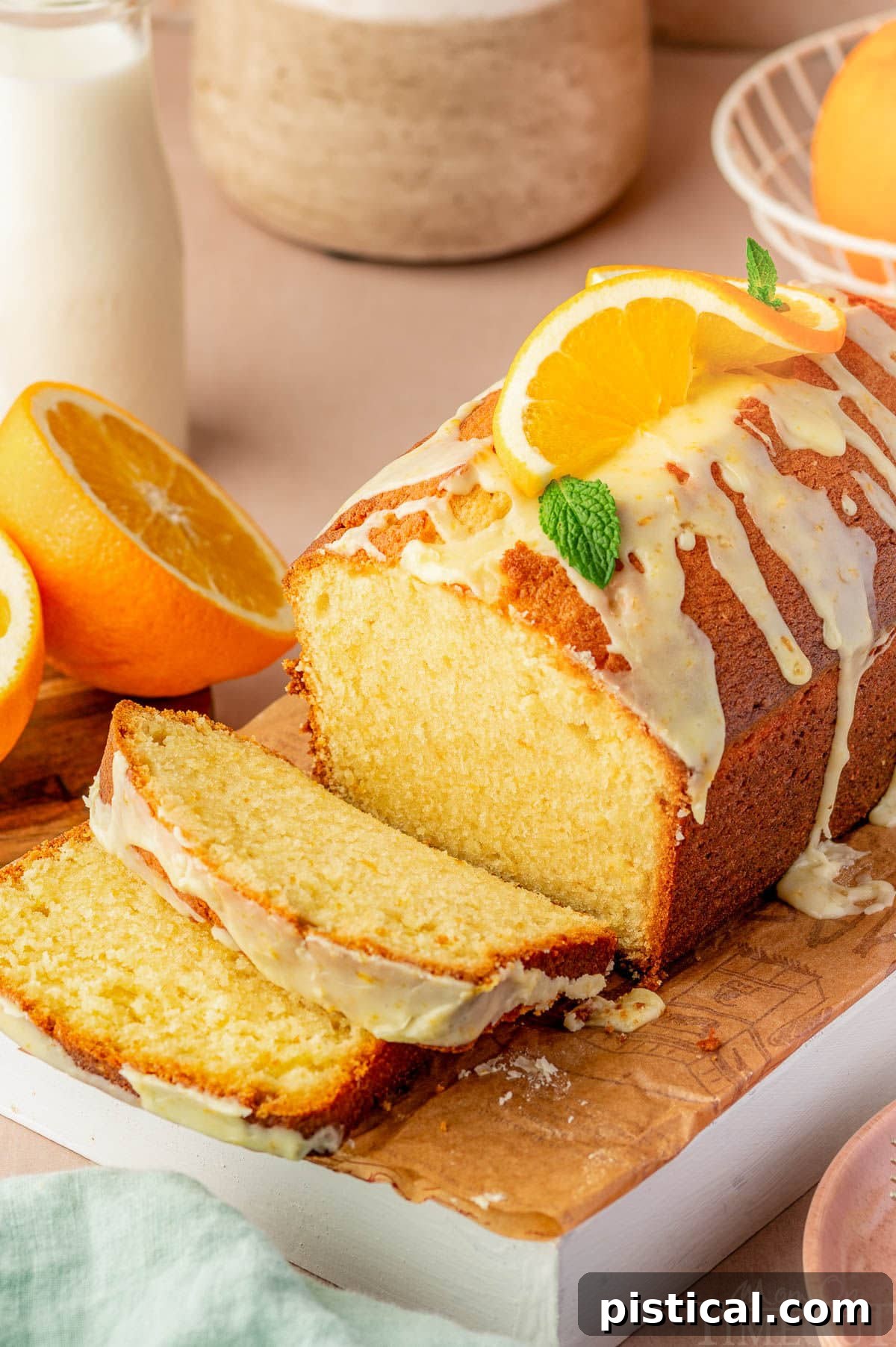 Zesty Orange Pound Cake 3 Top down angle shot of orange pound cake recipe topped with orange glaze on cutting board with two slices cut.