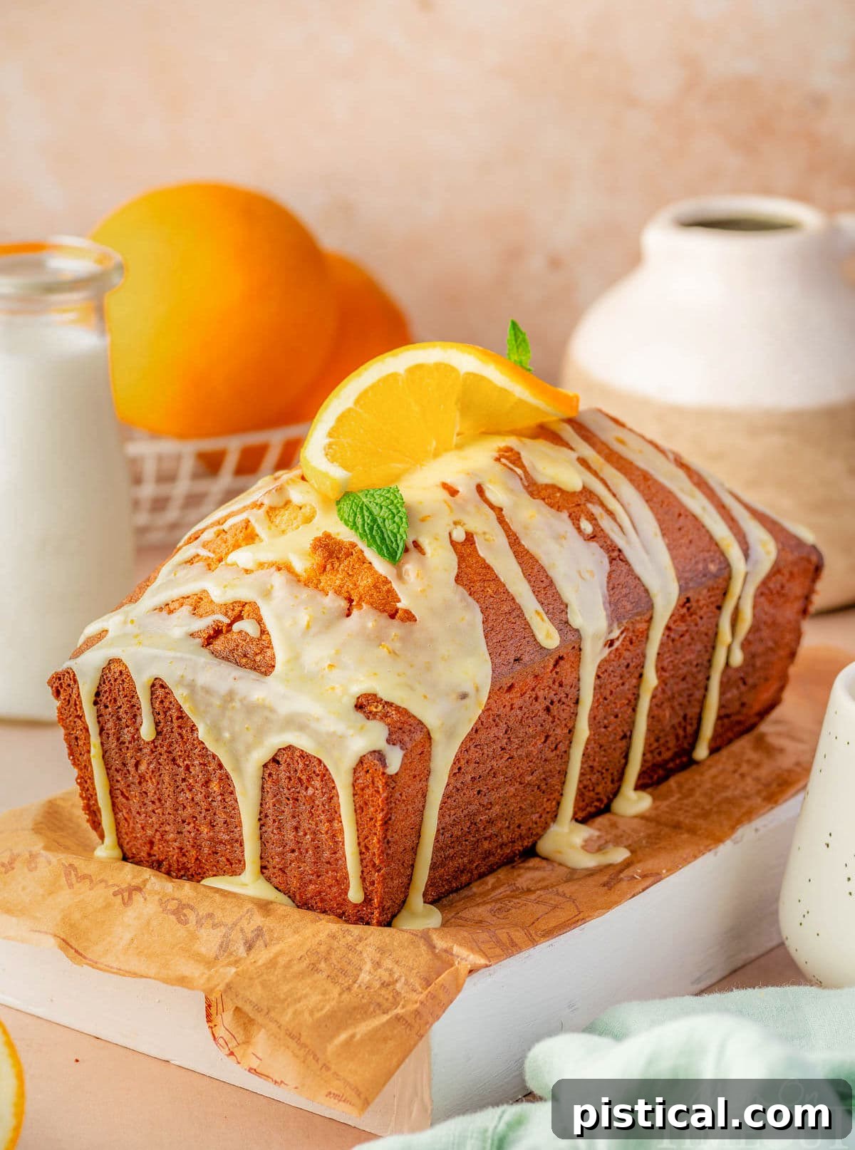 Zesty Orange Pound Cake 4 Whole orange pound cake with orange glaze sitting on wood cutting board ready to be enjoyed.