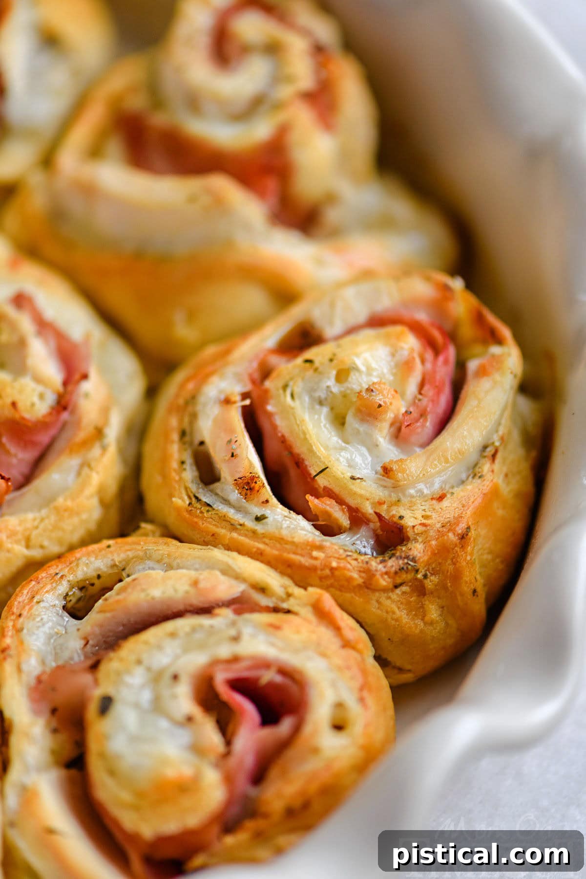 Golden brown Chicken Cordon Bleu Crescent Rolls in a white pie dish, ready to serve.
