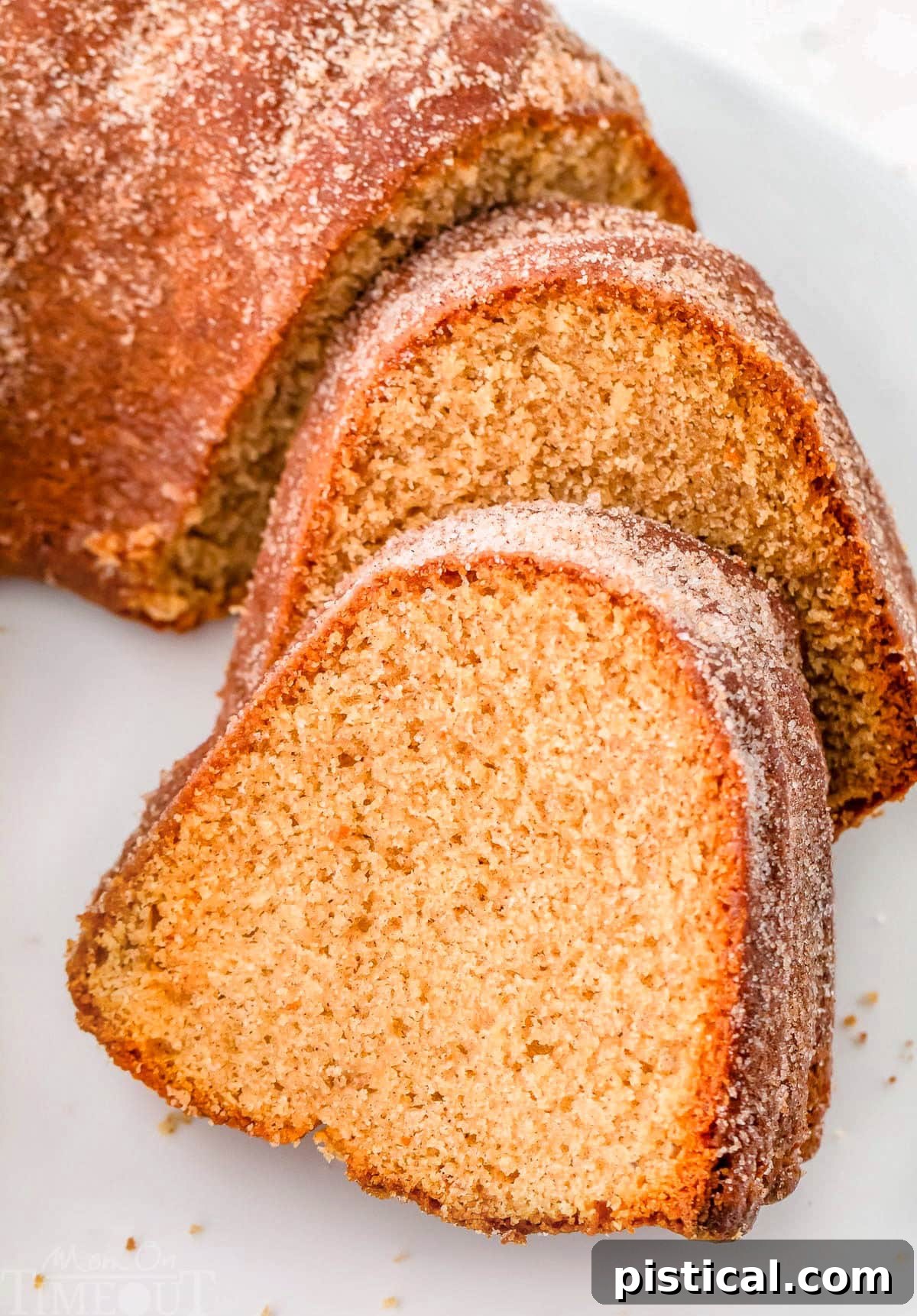 An angled down view revealing two perfectly sliced pieces of Apple Cider Bundt Cake, beautifully arranged on a white cake stand, ready to be enjoyed.