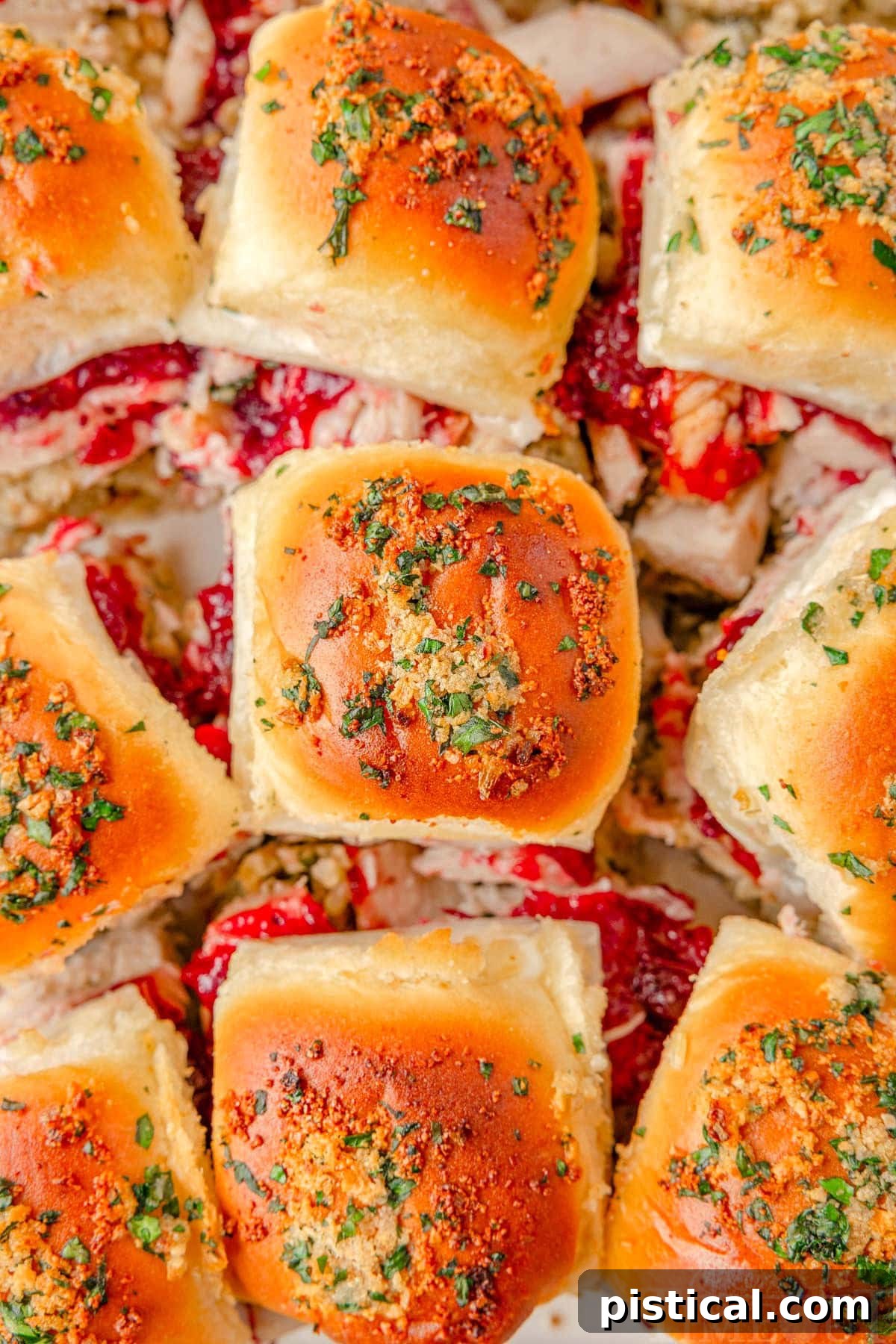 A close-up shot of perfectly baked turkey sliders, revealing their golden-brown tops and melted cheese peeking through the soft rolls.