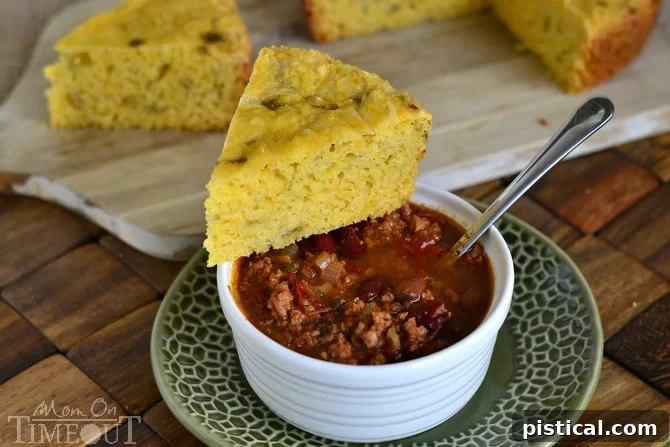 A slice of Slow Cooker Mexican Cornbread, moist and cheesy with green chiles, ready to serve with chili. | MomOnTimeout.com