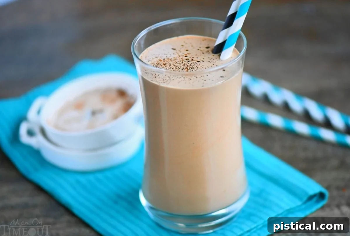 A wide-angle shot featuring a tall glass of protein shake with coffee, elegantly placed on a teal napkin. In the background, two small white bowls with ingredients hint at the wholesome components of this energizing beverage. A perfect blend of taste and nutrition.