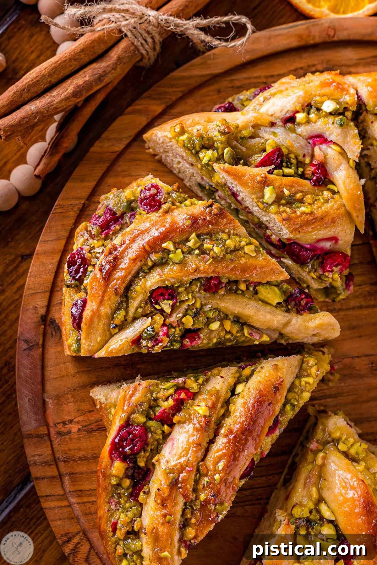 Festive Cranberry Pistachio Babka Crown 11 Four pieces of babka bread wreath cut up on a round board.