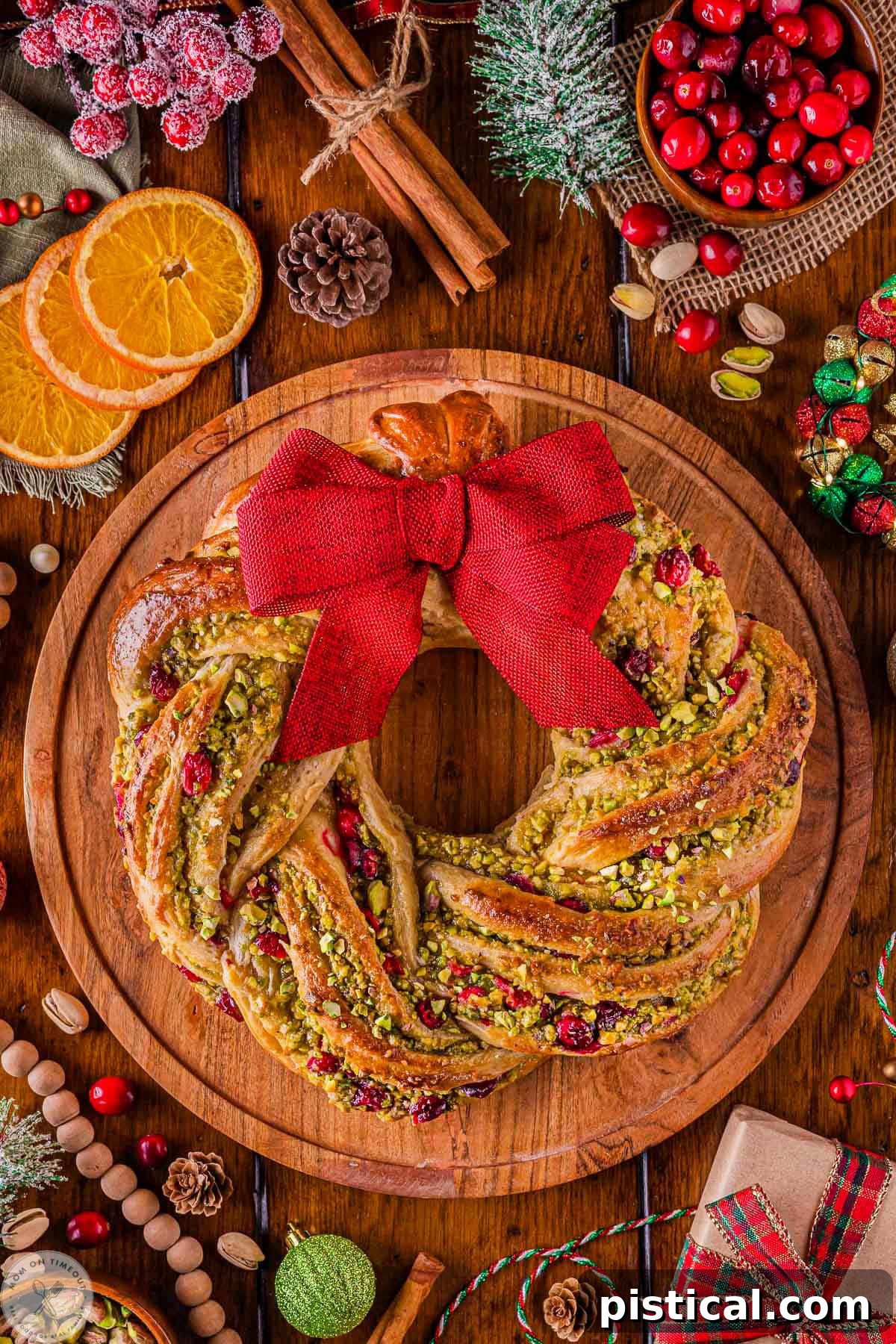 Festive Cranberry Pistachio Babka Crown 4 Overhead shot of cranberry pistachio babka shaped as a wreath sitting on round wood board.