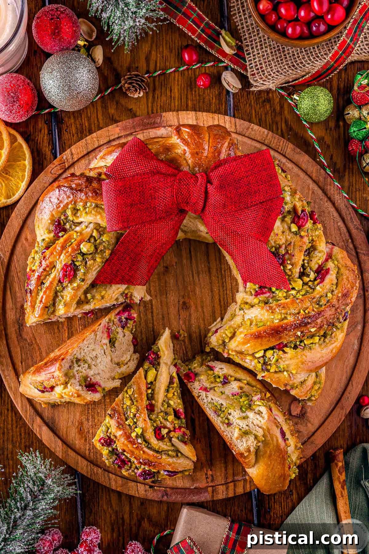 Festive Cranberry Pistachio Babka Crown 9 Whole babka wreath with three pieces cut out of the wreath.