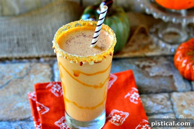 Close-up of a creamy Pumpkin Pie Milkshake with an artful caramel drizzle and crushed vanilla wafer rim.