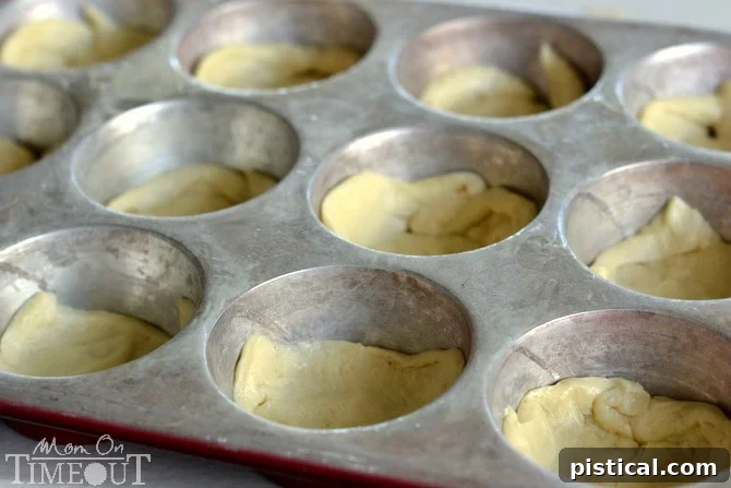Pillsbury Crescent rolls being pressed into a muffin tin to form the crust for mini quiches.