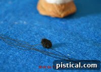 Gray felt ears being glued onto the Santa Mouse ornament