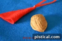 Whimsical Santa Mouse Ornament 8 Cotton ball being gently unrolled for creating the hat's fluffy trim