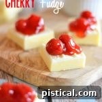 Close-up of a square of White Chocolate Cherry Fudge with a vivid red cherry on top.