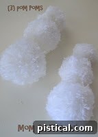 Three different sized pom poms ready for assembly to form a snowman