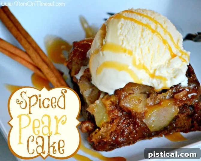 Close-up of a slice of Spiced Pear Cake showing the moist crumb and pear pieces, with a dollop of vanilla ice cream