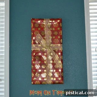 Picture frame wrapped in plaid Christmas paper, with a red bow