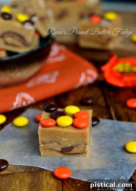 A slice of creamy Reese's Peanut Butter Fudge topped with colorful Reese's Pieces, showcasing the rich texture and delicious appeal.