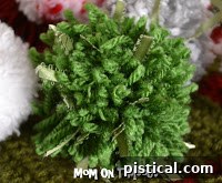 A pom pom made with multiple colors of yarn, showcasing a vibrant striped effect.