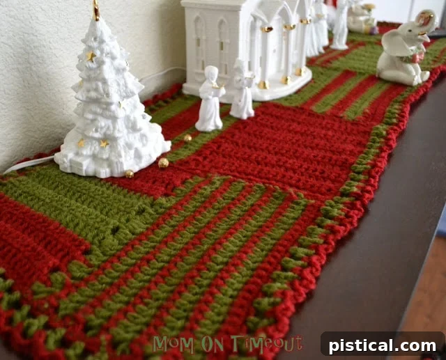 Close-up detail of the red and green crochet stitches forming the textured surface of the Christmas runner.