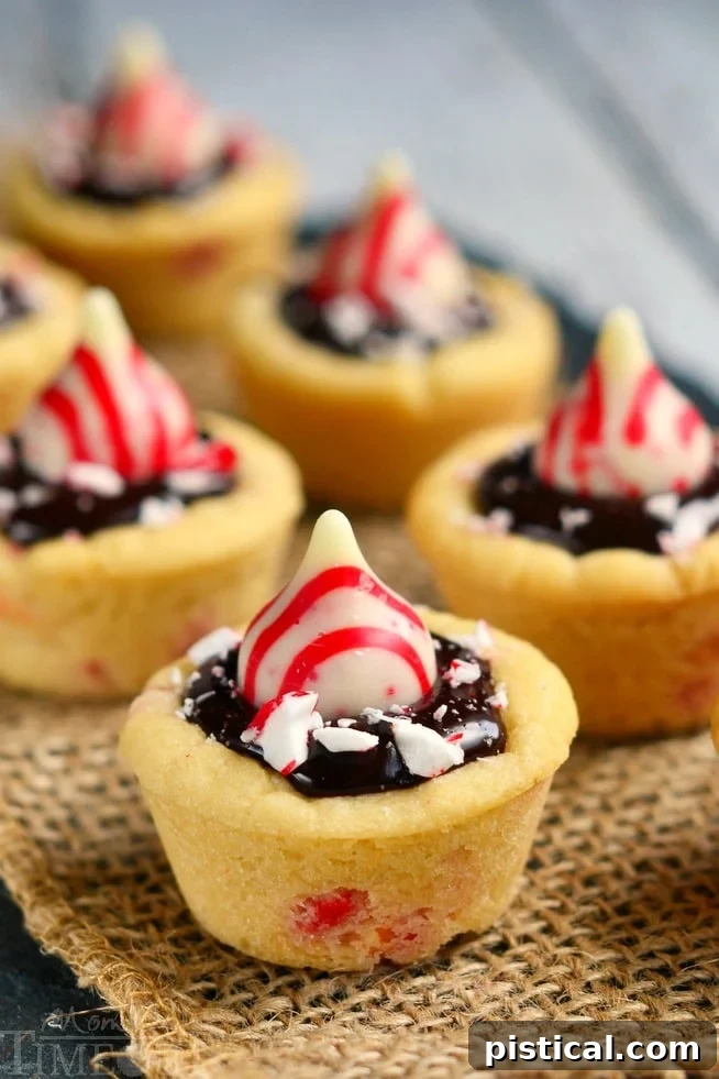 Decadent Dark Chocolate Peppermint Cookie Cups 3 Close-up of a Dark Chocolate Peppermint Sugar Cookie Cup with a melted Candy Cane Hershey's Kiss and crushed peppermint, showcasing its rich texture.