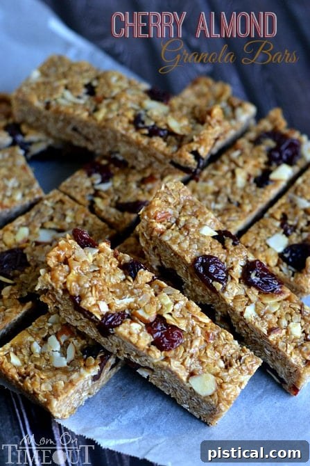 A stack of freshly made no-bake Cherry Almond Granola Bars, rich with dried cherries and sliced almonds, presented for a healthy snack.