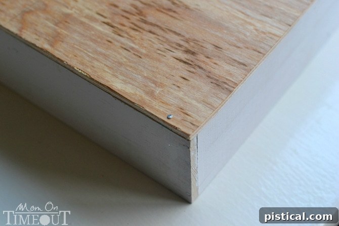 Nailing the plywood base to the wooden dividers of the DIY drawer organizer.
