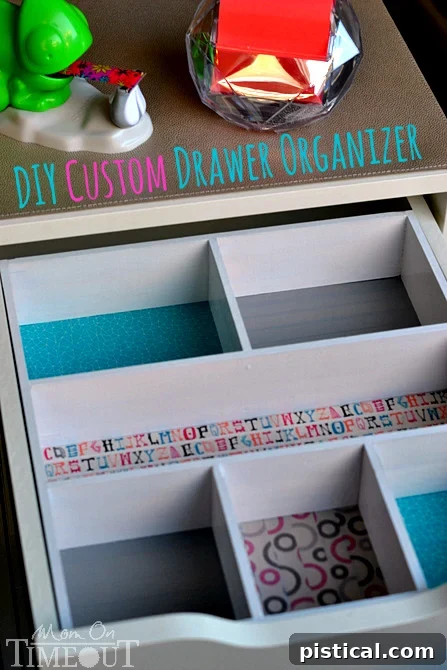 Overhead view of a colorful DIY drawer organizer with various Washi tape designs, holding office supplies.
